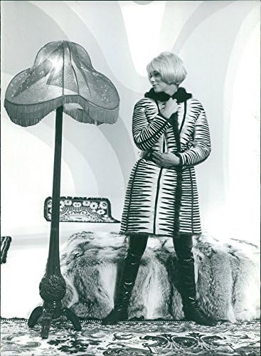 Гроздобер фотографија на Миреил Дарк која стои облечена во палто.